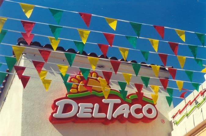 Blade flags on pennant strings in front of Del Taco